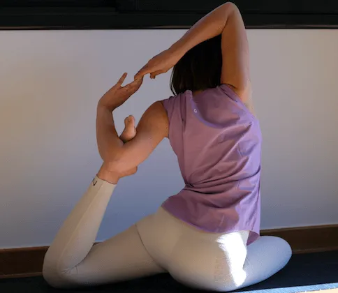 Irene Serra en un posat de ioga asseguda amb les mans encaixades per darrere, mostrant connexió i harmonia en Yoguipick.